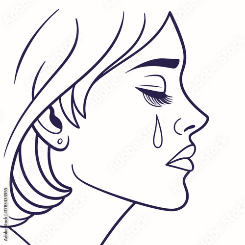 A woman in profile is crying with a tear rolling down her cheek