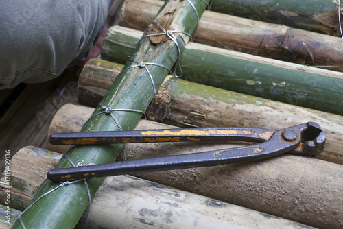 Wallpaper Mural Close up of rusty pincer tool resting on handmade bamboo raft. Construction project showing rustic building with natural material and traditional method Torontodigital.ca
