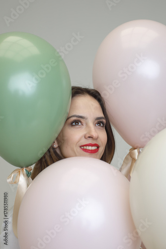 fashionable woman with balloons on studio background
