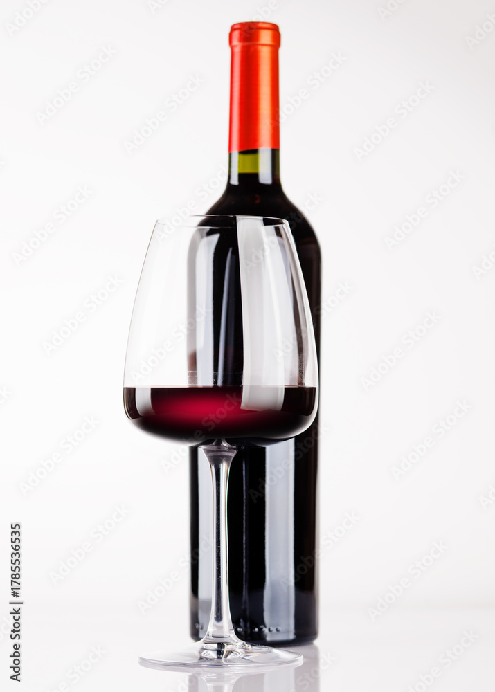 Naklejka premium Red wine bottle and glass on white background