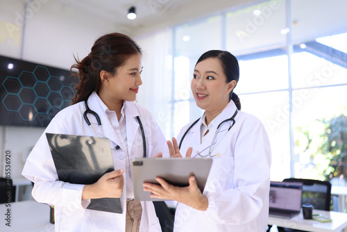 Two medical doctors woman checking the patient papers in  hospital, Medical technology and Healthcare concept. 