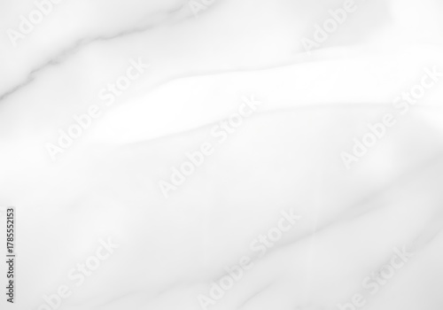 Elegant white marble texture with subtle gray veining, featuring a smooth reflective surface and a bright light highlight