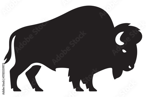  A powerful black silhouette of a standing bison facing left with horns and shaggy fur detail silhouette