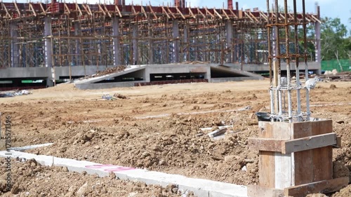 Construction site steel reinforcement concrete foundation soil unfinished building structural framework outdoor daytime development progress with foundation, steel reinforcement, soil, and partially