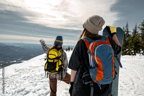 Wallpaper Mural Two young girls snowboarders are standing with snowboards at mountain top and looks at the view. Ski resort and winter vacations Torontodigital.ca