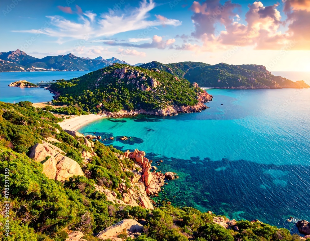 Obraz premium Aerial view showcases vibrant turquoise waters, green islands, a sandy beach, and a colorful sunset