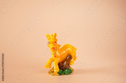 A horse figurine on a pink background.