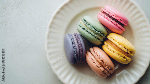 白っぽいテーブルの上に置かれたカラフルなマカロンを真上から捉えた俯瞰ショット