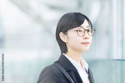 スーツを着て、緊張した表情をしている若い女性