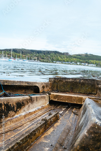 Wallpaper Mural Small rowboat on a rocky beach at a busy marina in the Scottish Highlands Torontodigital.ca