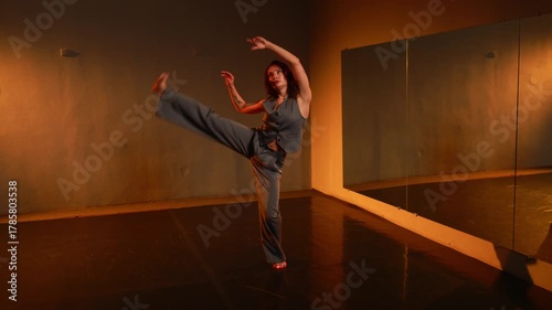 Young woman performs contemporary dance in an empty studio