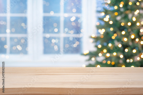 Wooden table top for product display on blurred Christmas fir tree lights and festive window interior background