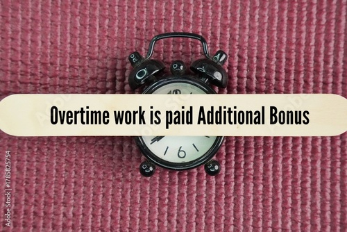 Alarm clock and stick with the words Overtime work is paid Additional bonus. Overtime concept 