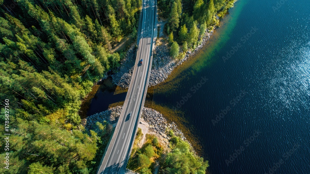 Fototapeta premium Serene Passage: Aerial View of Bridge Over Lake and Forest