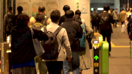 TOKYO, JAPAN - NOV 2025 : Automatic ticket gate at the train station. Crowd of people passing through the gate. Japanese urban city life, transportation, traffic and commute concept slow motion shot..