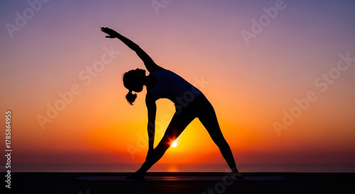 Silhouette of a woman practicing yoga at sunset, promoting wellness and fitness