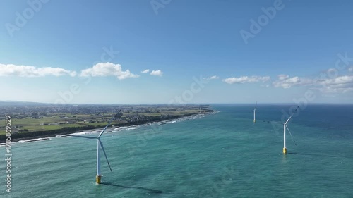 冬が近く風の強い富山湾沿岸の洋上風力発電風車や波のかかる離岸堤などの風景