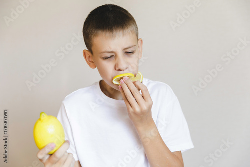 Boy eating fresh lemon isolated on white background. Citrus.portrait boy with lemon.