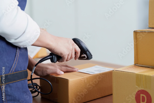Inventory Management. Employee scanning package with barcode scanner in warehouse.