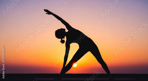 Silhouette of a woman doing yoga at sunset with an orange sky