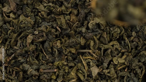 Dried green tea leaves scooping with spoon