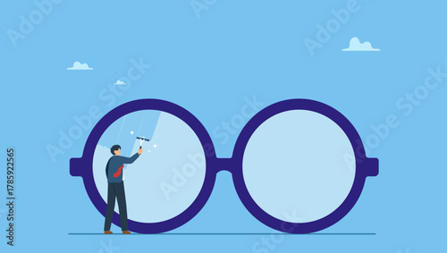 Businessman cleaning huge eyeglass lenses for owner to get clear vision. Clear business vision, see through lenses in details or clean and clear business outlook.