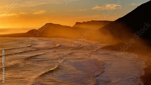 Aerial view of the coastline where the golden light kisses the land and sea, creating a mesmerizing dance of colors, Cape Town, Western Cape, South Africa.