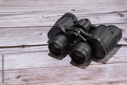 Binoculars on a wooden table. Black binoculars. Set of black binoculars on wooden background