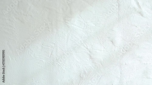 Textured white wall surface showing light shadows and subtle patterns