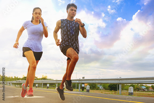 Silhouette of young couple running together on road across the bridge. Couple, fit runners fitness runners during outdoor workout