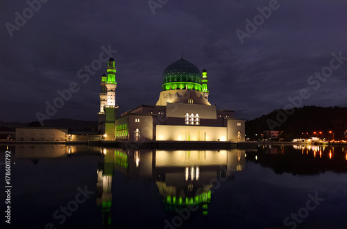 Evening view of Masjid Bandaraya Kota Kinabalu, a famous landmark and tourist attraction in Borneo, glowing at dusk with water reflection