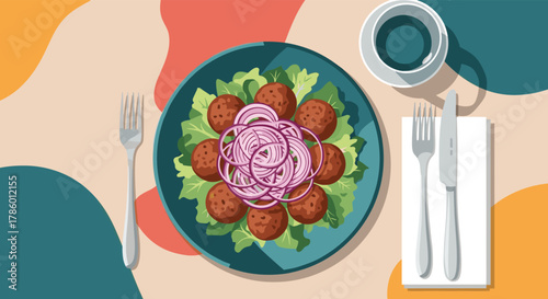 Overhead view of a colorful plate of falafel and salad with red onion rings, served with cutlery and a drink.