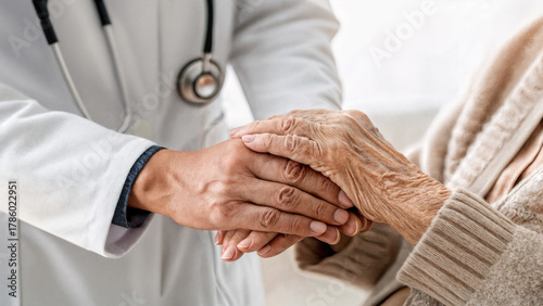 close-up of a doctor holding an elderly patient's hands for support