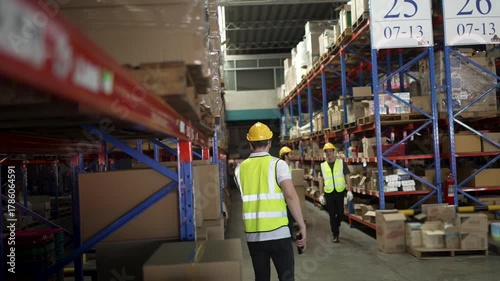 Blue collar workers are working at warehouse. Logistics, transportation.