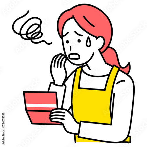 預金残高が減ってショックを受けるエプロン姿の女性