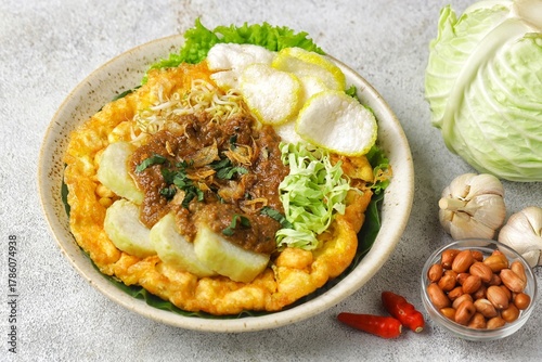 Tahu tek, tahu gunting, tahu telur is a typical Surabaya food consisting of fried tofu, rice cake, fried potatoes, bean sprouts and cucumber, which are drizzled with peanut sauce.