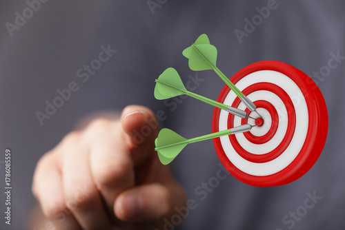 Hand pointing at a dartboar...