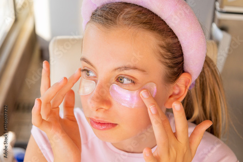 preteen girl using pink sparkling eye patches fun beauty concept