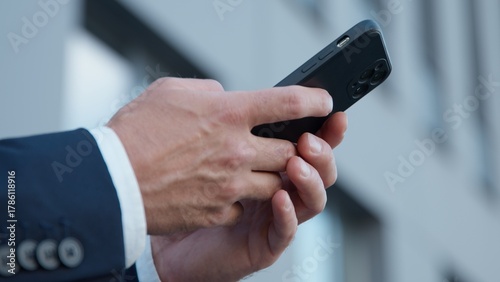 Close-up male hands holding mobile phone in city unrecognizable business man chatting with smartphone device unknown businessman with cellphone sending sms message using online cyberspace internet