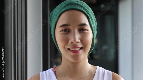 Confident encouraged hopeful healthy asian woman cancer patient with head scarf getting a good cure in rehabilitation facility, real female person model