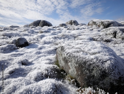 Expansive Winter Landscape Frost-Covered Rocks Field Blue Sky White Clouds Cold Outdoors Nature Scenery Snowy Ground Granite Boulders