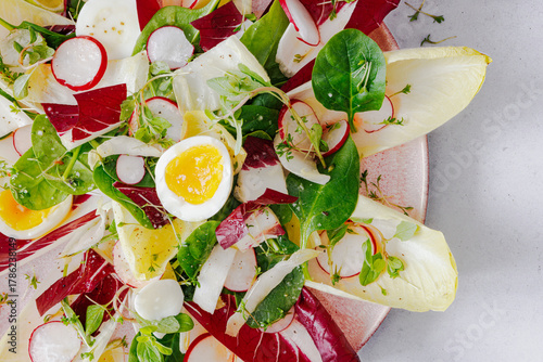Salat mit Chicoree, Radicchio, Radieschen, gekochten Eiern und Limettendressing