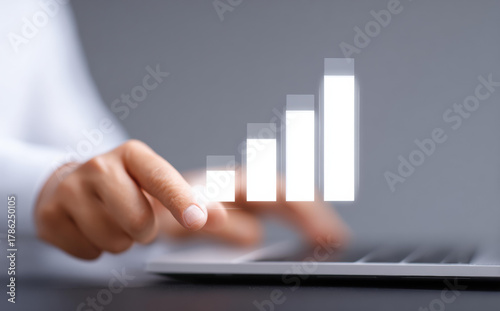 Focused business person using technology for finance data analysis. Touching virtual growth chart and graph showing success, illustrating positive business strategy