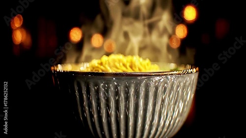 Steaming Noodles In A Decorative Bowl With Blurred Lights In The Background, Close Up View