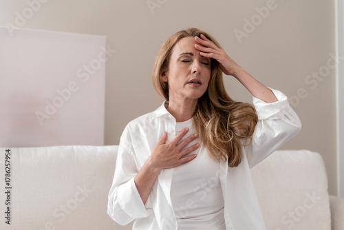 Mature woman experiences panic attack with chest pain and breathing difficulties