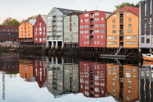 Brightly painted wooden houses on stilts line the Trondheim harbor