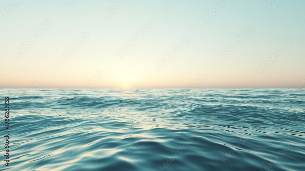 Fototapeta premium Calm ocean waves reflecting soft sunrise light in a peaceful setting near the horizon at dawn