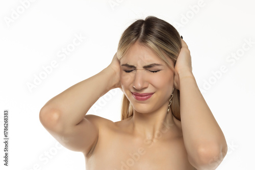 Wallpaper Mural Studio shot of a woman covering her ears with both hands, eyes closed and grimacing from loud noise, on a white background Torontodigital.ca