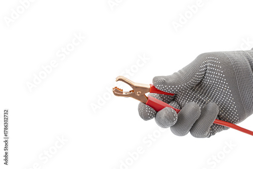 Foto Gloved hand holds opened alligator clip with red cable, isolated on white background