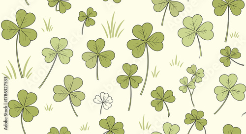 Seamless pattern of green shamrocks and clover leaves on a pale yellow background, evoking luck, St. Patrick's Day, and spring themes.